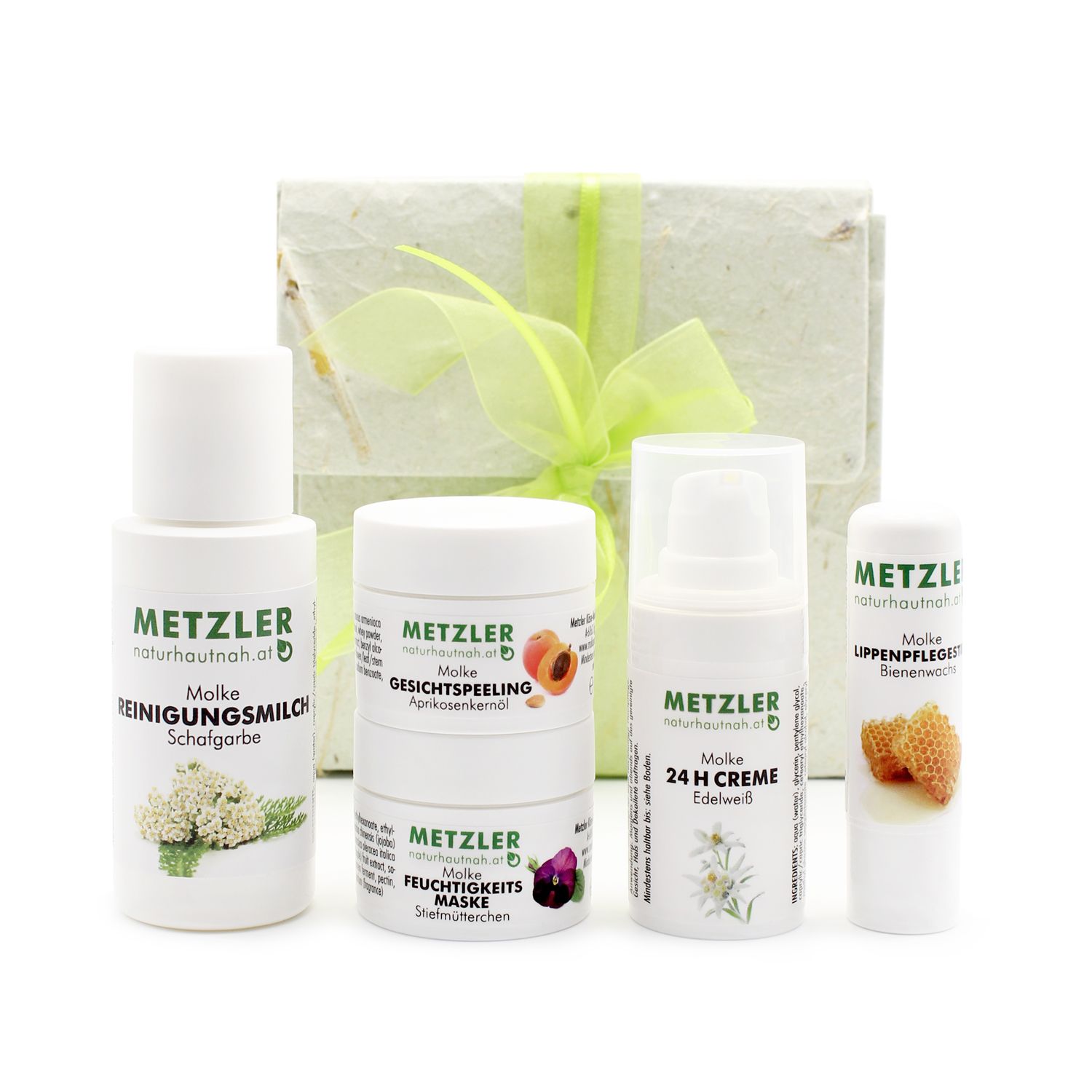 Geschenkset mit 4 Kosmetikprodukten. Weiße Flaschen und Tiegel. Text: METZLER naturhautnah.at. Mit Geschenkbox und Schleife.