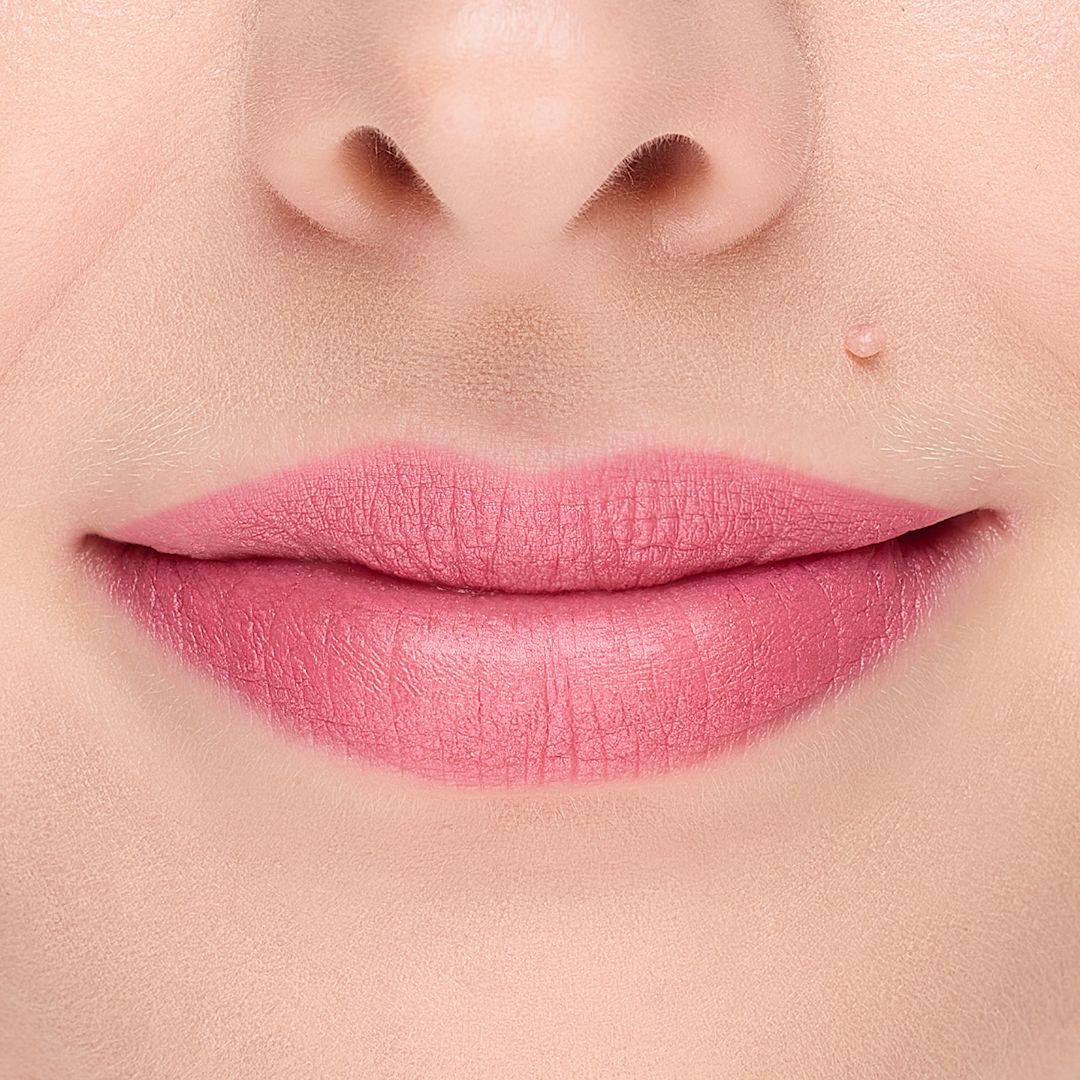 Ein Mund mit perfekt aufgetragener, matter rosa Lippenfarbe. Die Lippenkontur ist präzise definiert.
