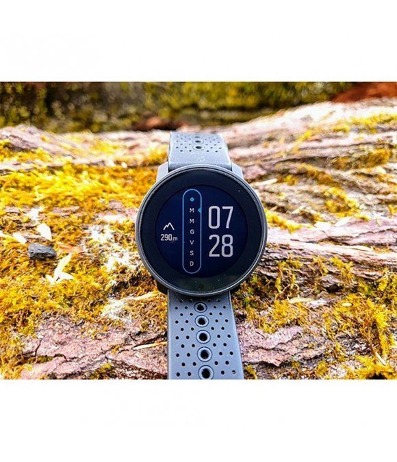Graue Smartwatch mit perforiertem Armband. Anzeige: 07:28, Berg- und Tal-Symbol. Auf Holz und Moos platziert.