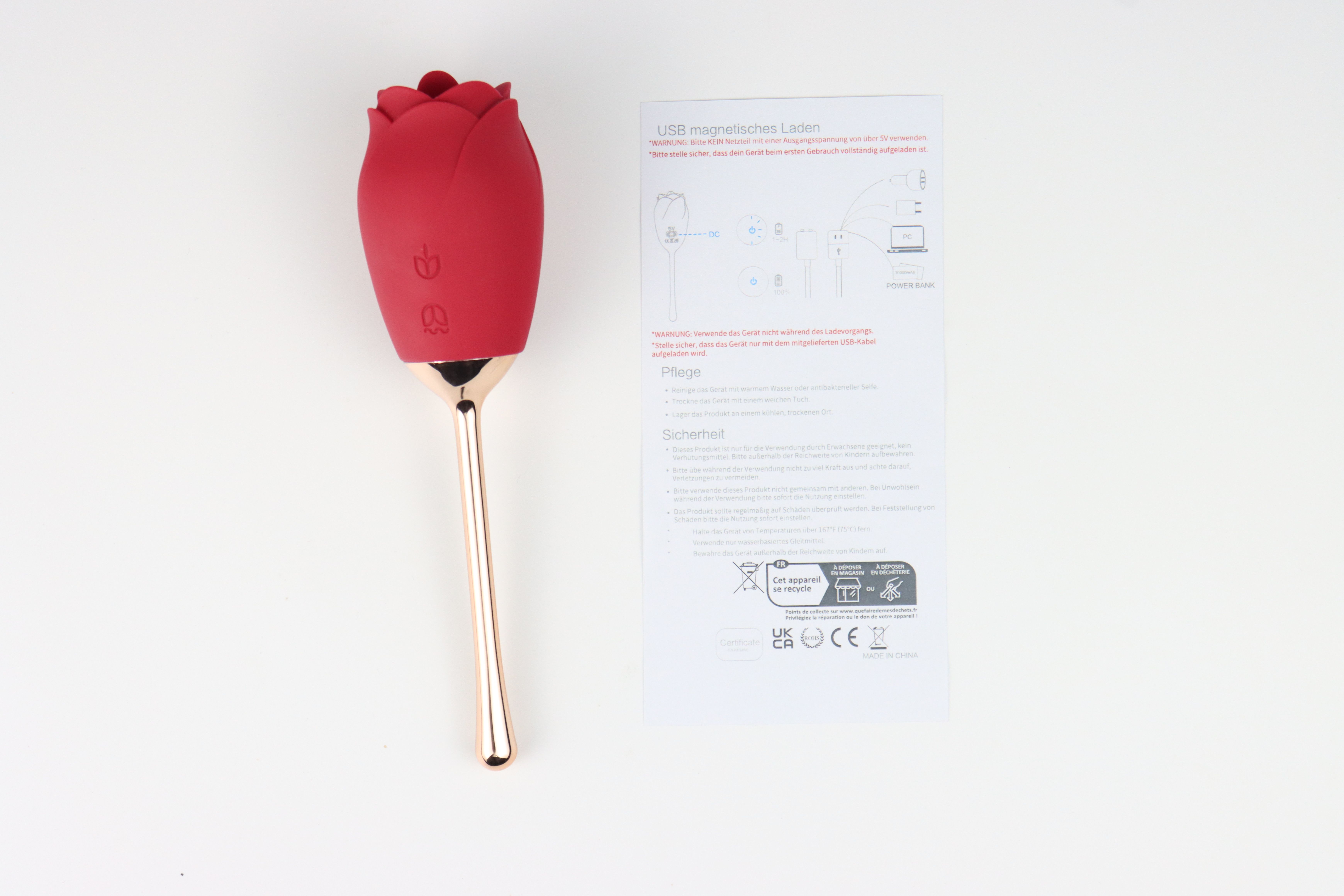 Roter Vibrator in Rosenform mit Stiel und Bedienungsanleitung. Text auf Anleitung.
