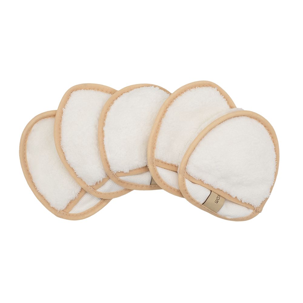 Fünf weiße Abschminkpads mit beigem Rand. Die Pads sind übereinander gestapelt und leicht versetzt angeordnet.