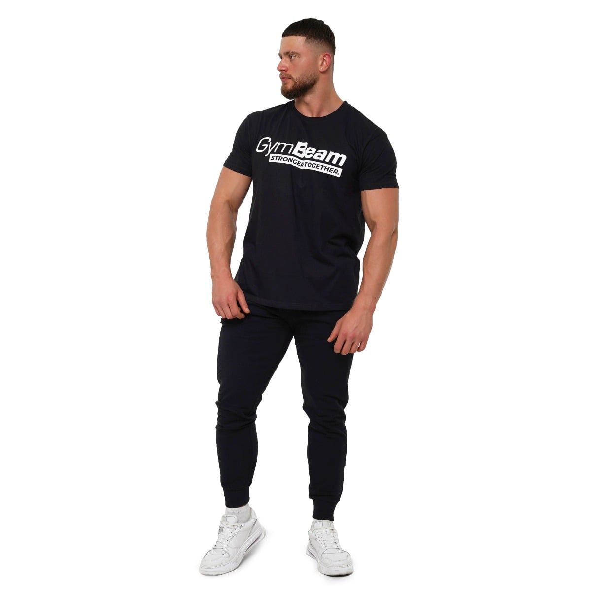 Mann in schwarzem GymBeam T-Shirt und Jogginghose, Ganzkörperansicht.