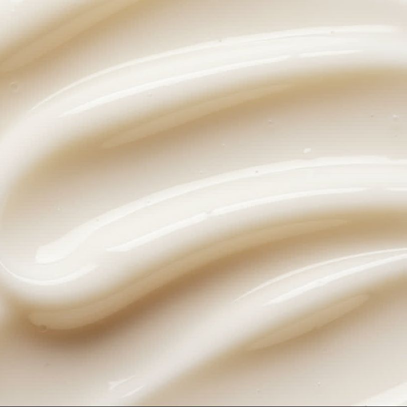 Nahaufnahme von cremiger, weißer Creme mit wellenförmiger Textur. Glänzende Oberfläche.