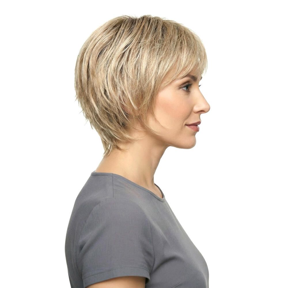 Kurzhaarperücke, blond, mit Pony, Seitenansicht. Natürlicher Haarfall. Frau trägt graues Oberteil.