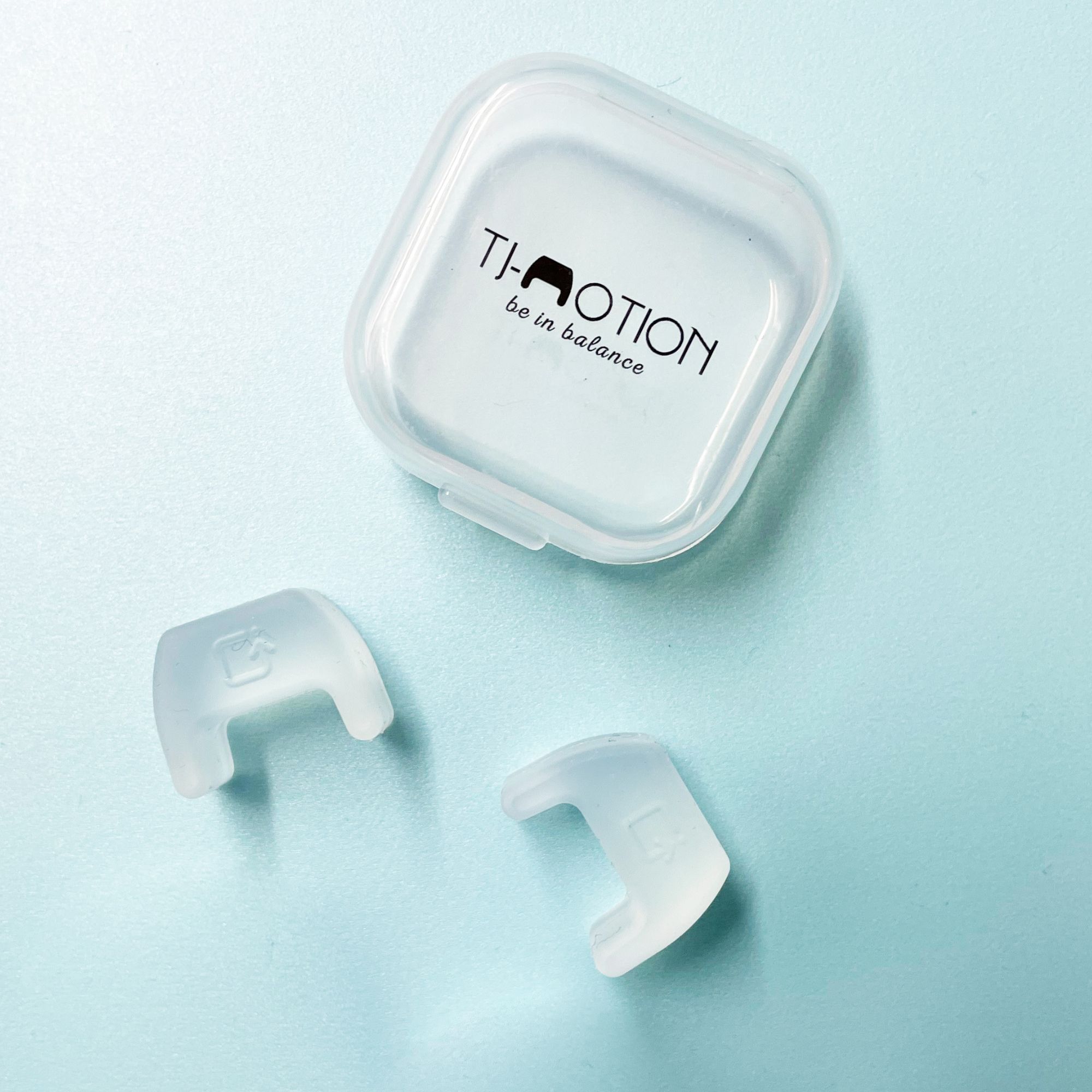 Zwei transparente Produkte und eine transparente Box. Aufschrift: TJ-Motion be in balance.