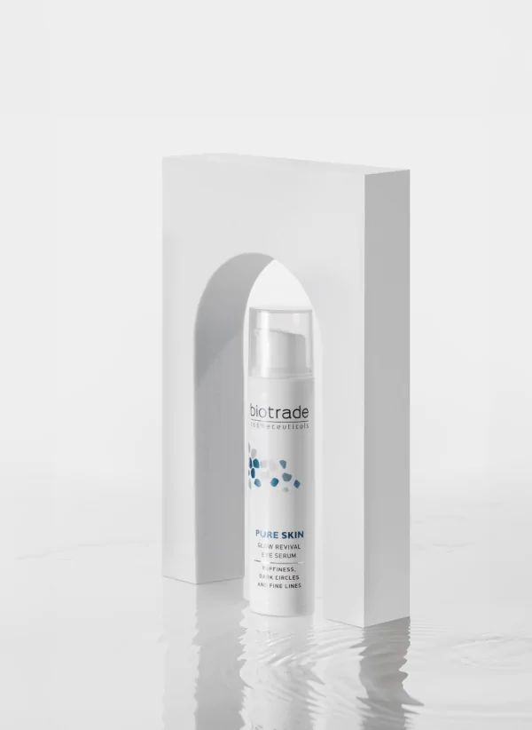 Weißes Produkt in weißem Bogen, Biotrade-Logo, Pure Skin Glow Revival Eye Serum, gegen Schwellungen, Augenringe und feine Linien.