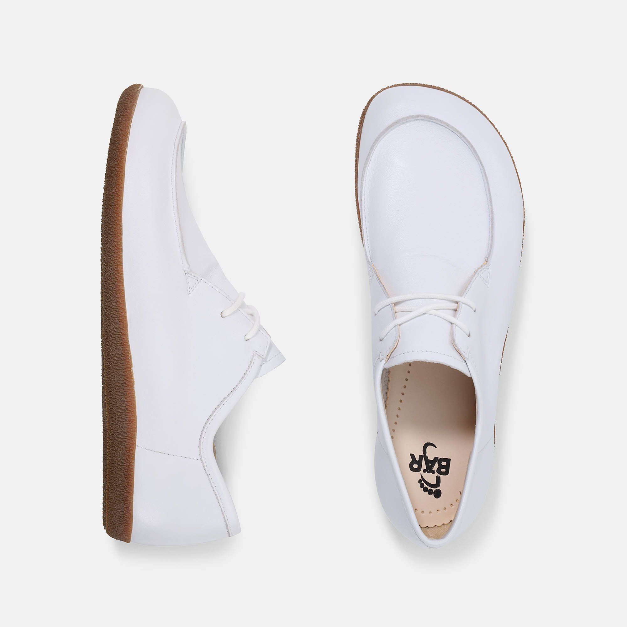 Zwei Schuhe, weiss, mit brauner Sohle. Ansicht von oben. Auf einem Schuh ist das Logo BÄR zu sehen.