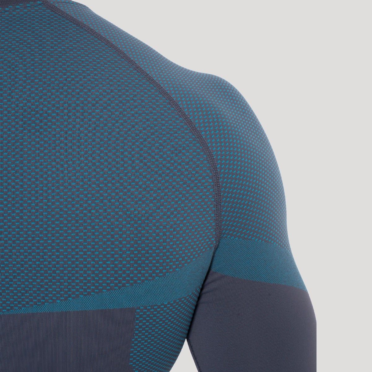 Detailansicht der Schulterpartie eines grauen, eng anliegenden Herren-Langarmshirts.