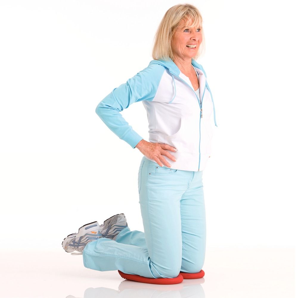 Frau kniet auf zwei roten Dynair Pads.