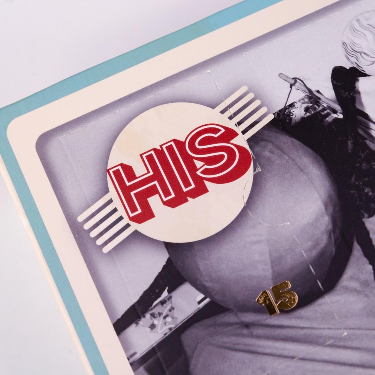 Detailansicht des Adventskalenders mit dem Logo „HIS“ in einem Kreis. Vintage-Bild eines Mannes im Hintergrund.