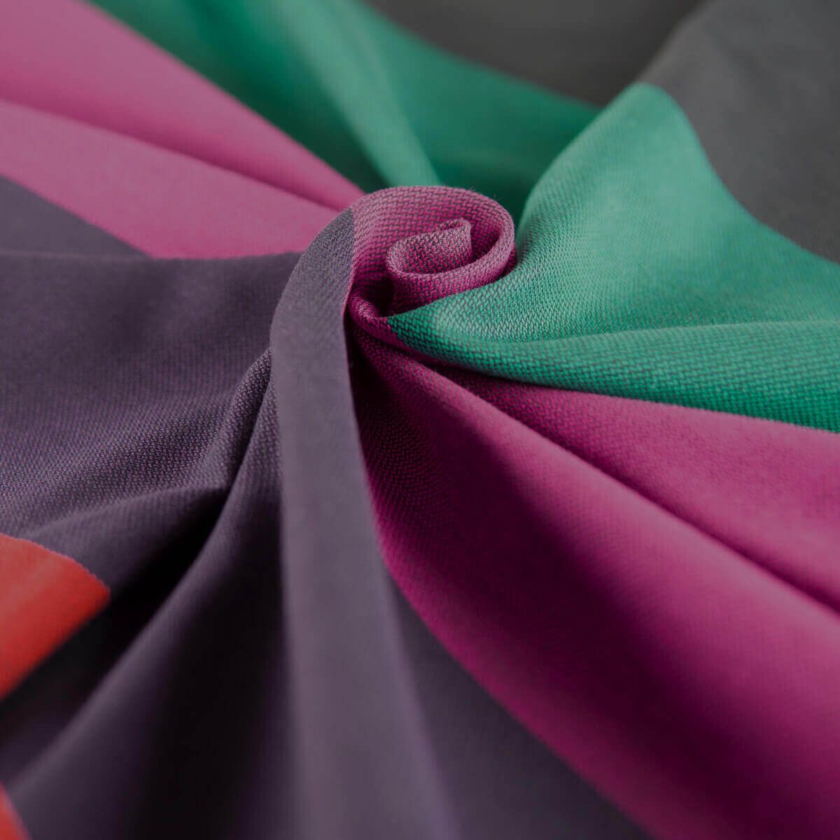 Nahaufnahme des Stoffes eines Ring-Slings. Mehrere farbige Streifen, darunter Lila, Grün und Rosa. Stoff gefaltet.
