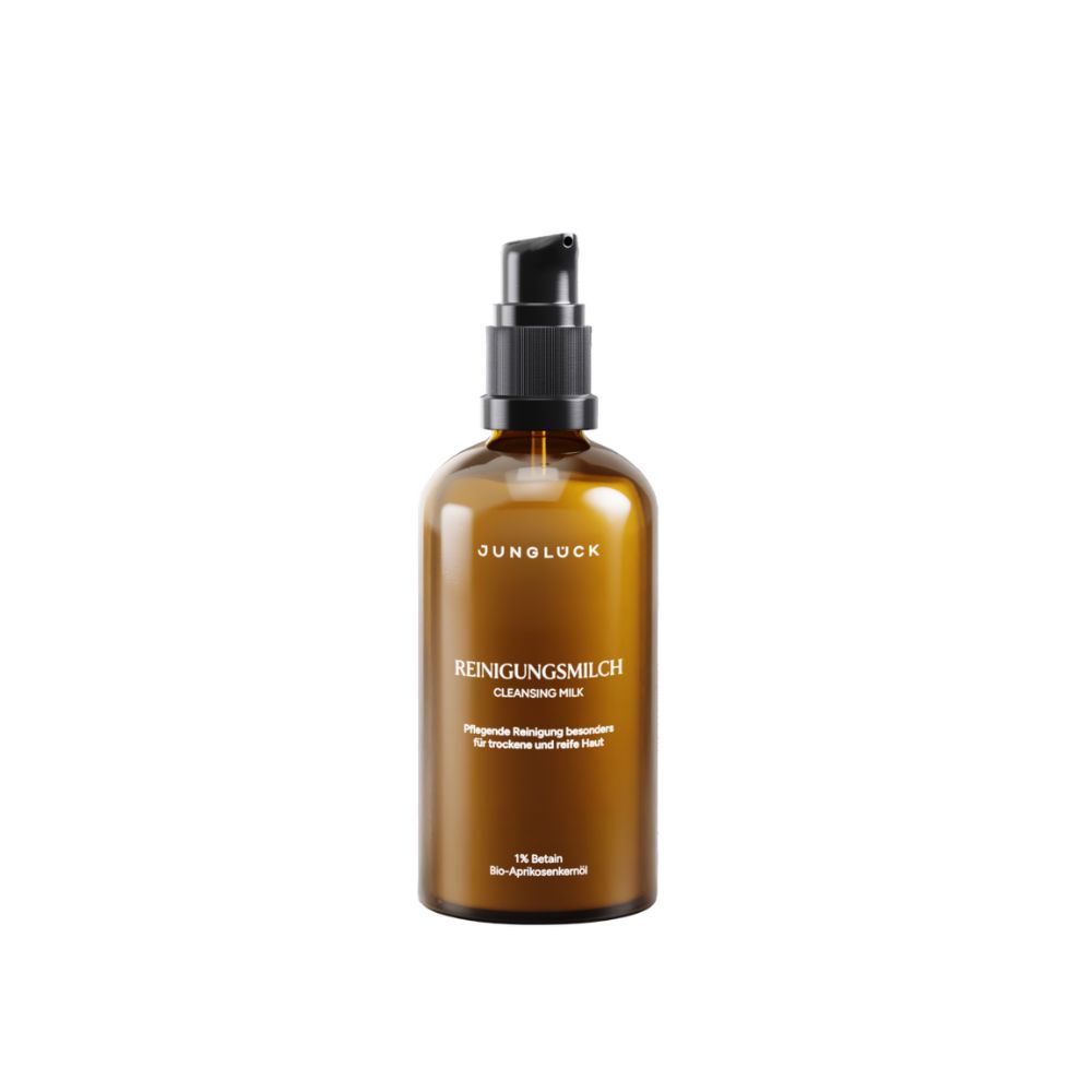 Braune Glasflasche mit schwarzem Pumpkopf. Aufschrift: JUNGLÜCK, Reinigungsmilch, Cleansing Milk.