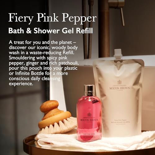 Molton Brown Fiery Pink Pepper Bade- und Duschgel Nachfüllpackung neben Produktflasche. Abgebildet mit Bürste und Waschbecken.