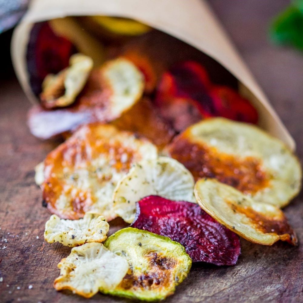 Gemüsechips in Papiertüte. Verschiedene Sorten und Farben.