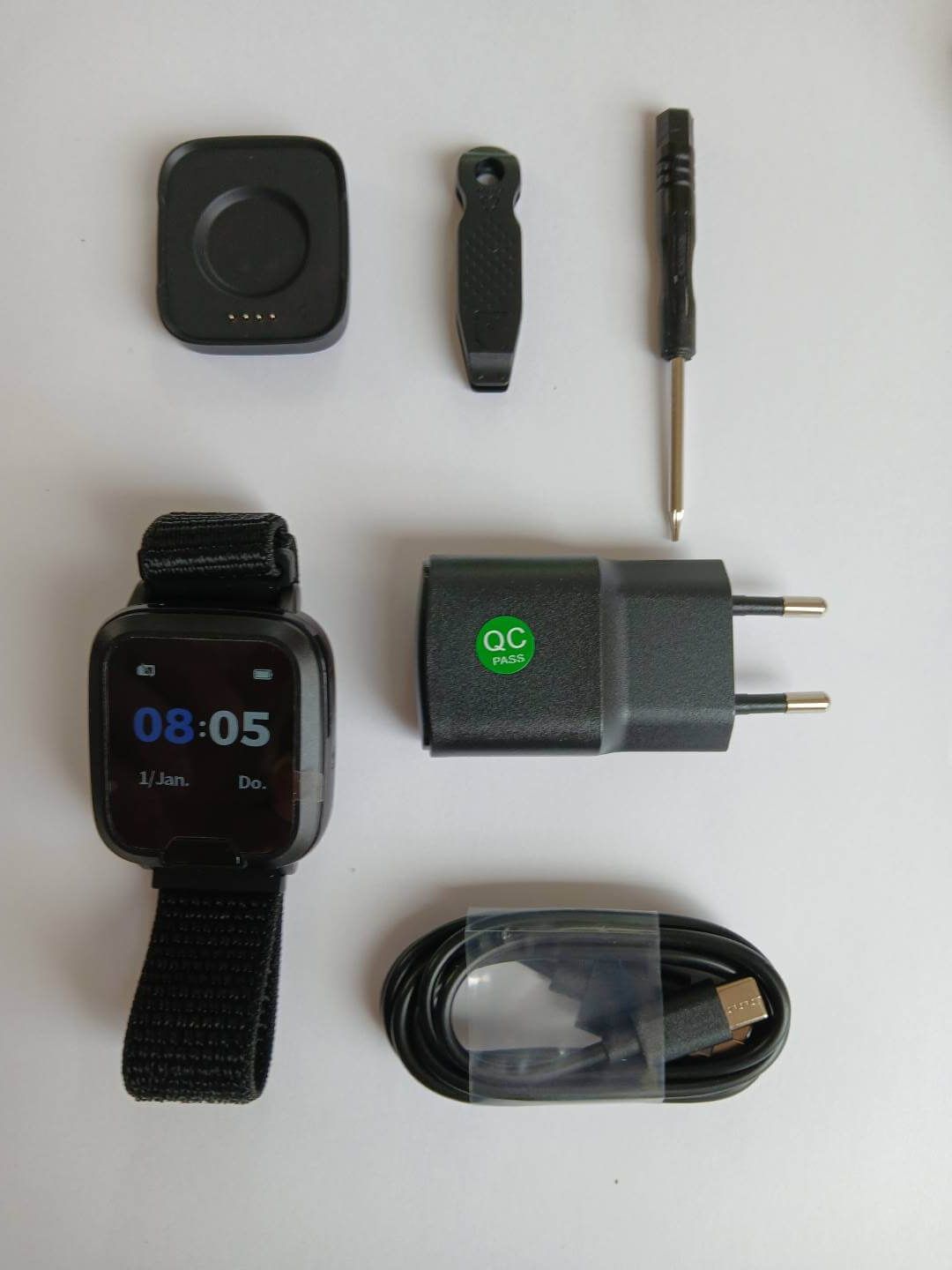 Zubehör für Notruf-Armband: Ladestation, Clip, Schraubendreher, Netzteil, Kabel.