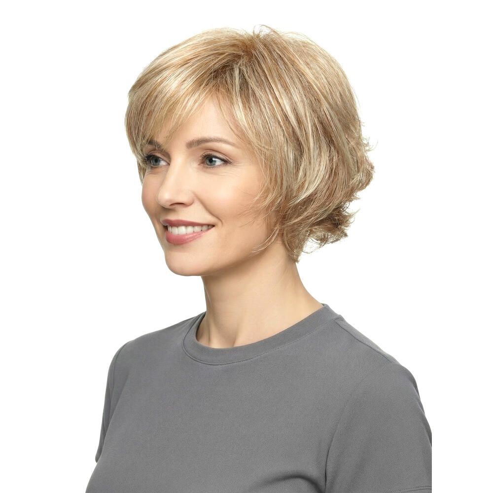 Blonde Perücke mit kurzem, gestuftem Schnitt. Die Frau trägt ein graues T-Shirt. Seitenansicht mit Lächeln.
