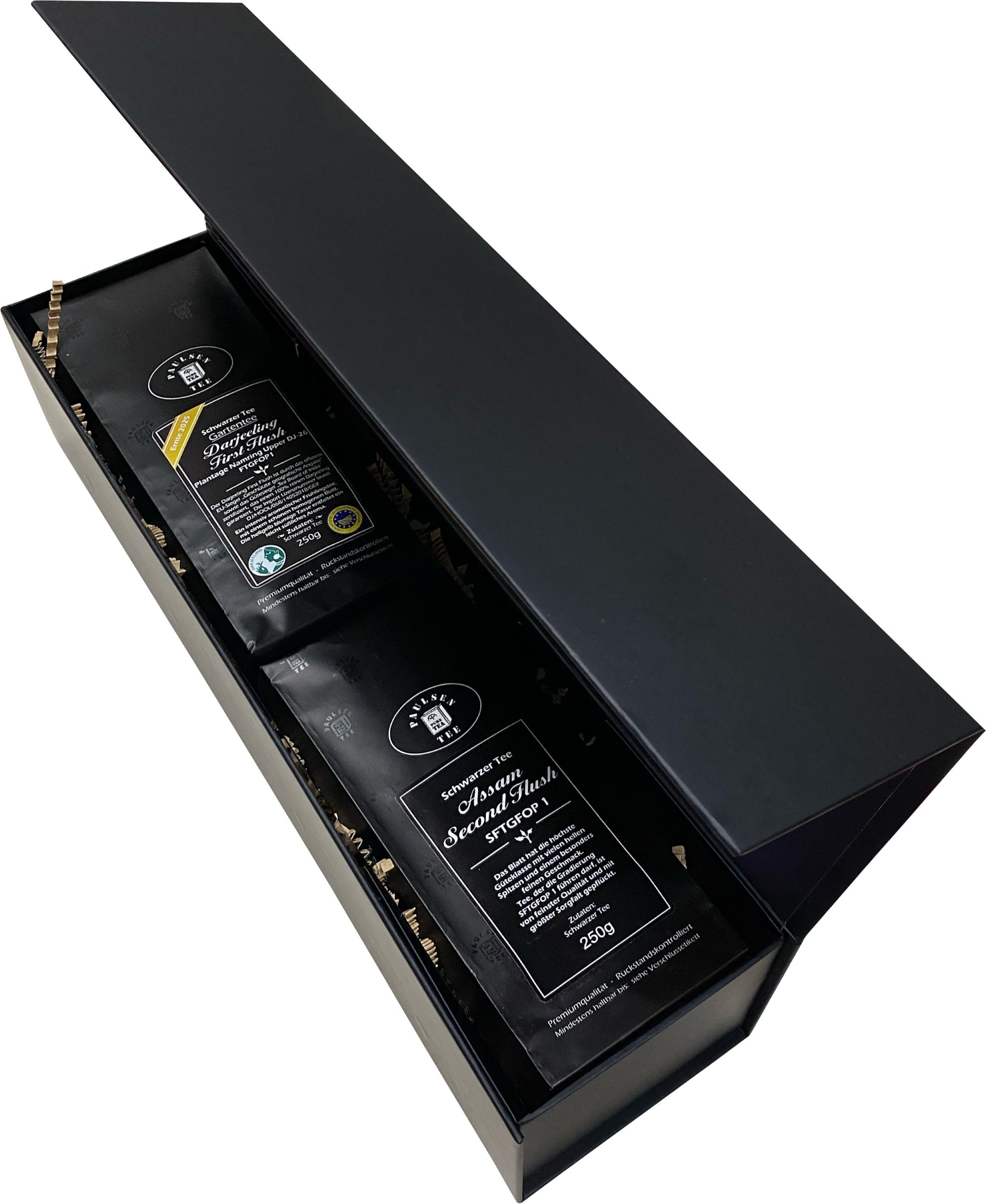 Geschenkkarton mit zwei Tee-Packungen. Schwarze Schachtel, geöffnet. Enthält Darjeeling und Assam Tee.