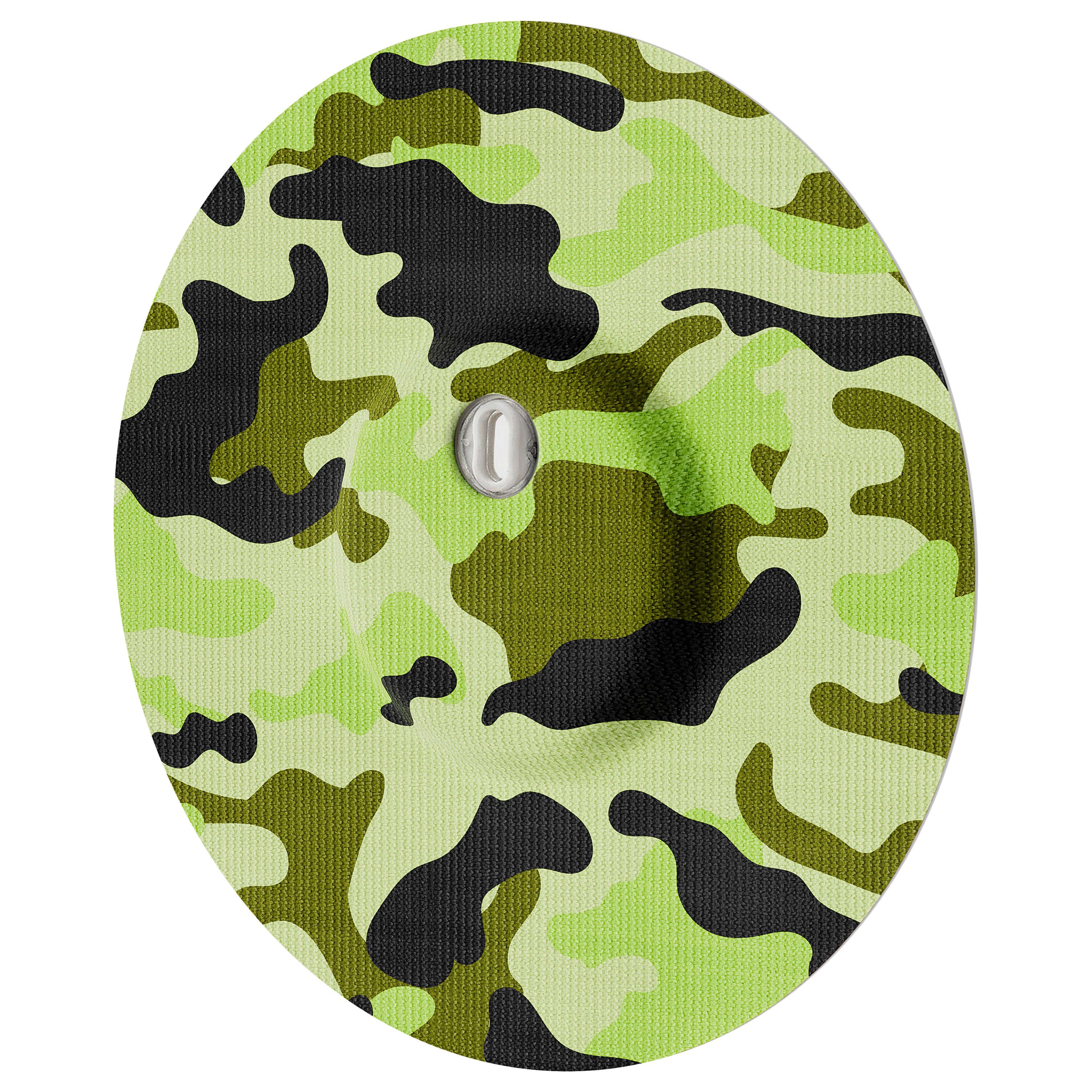 Rundes Pflaster mit Camouflage-Muster in Grün- und Schwarztönen, mit zentralem, silberfarbenem Element.