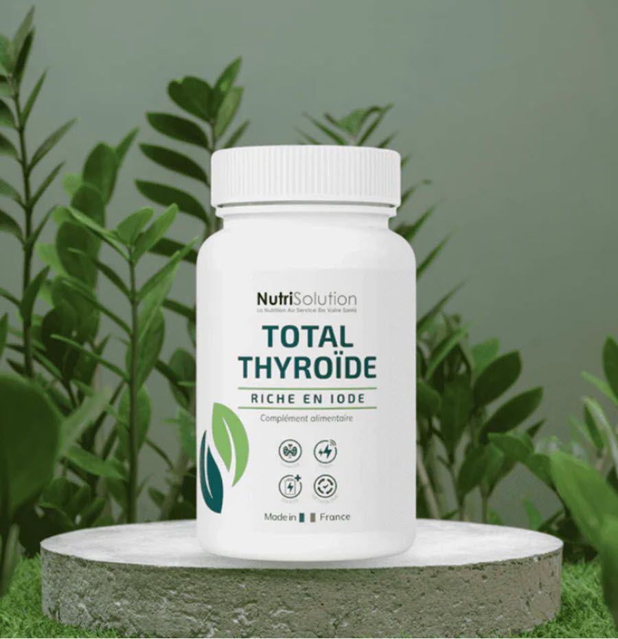 Weiße Flasche "TOTAL THYROÏDE". Nahrungsergänzungsmittel. "NutriSolution"-Logo und grüne Blätter. Auf Podest.