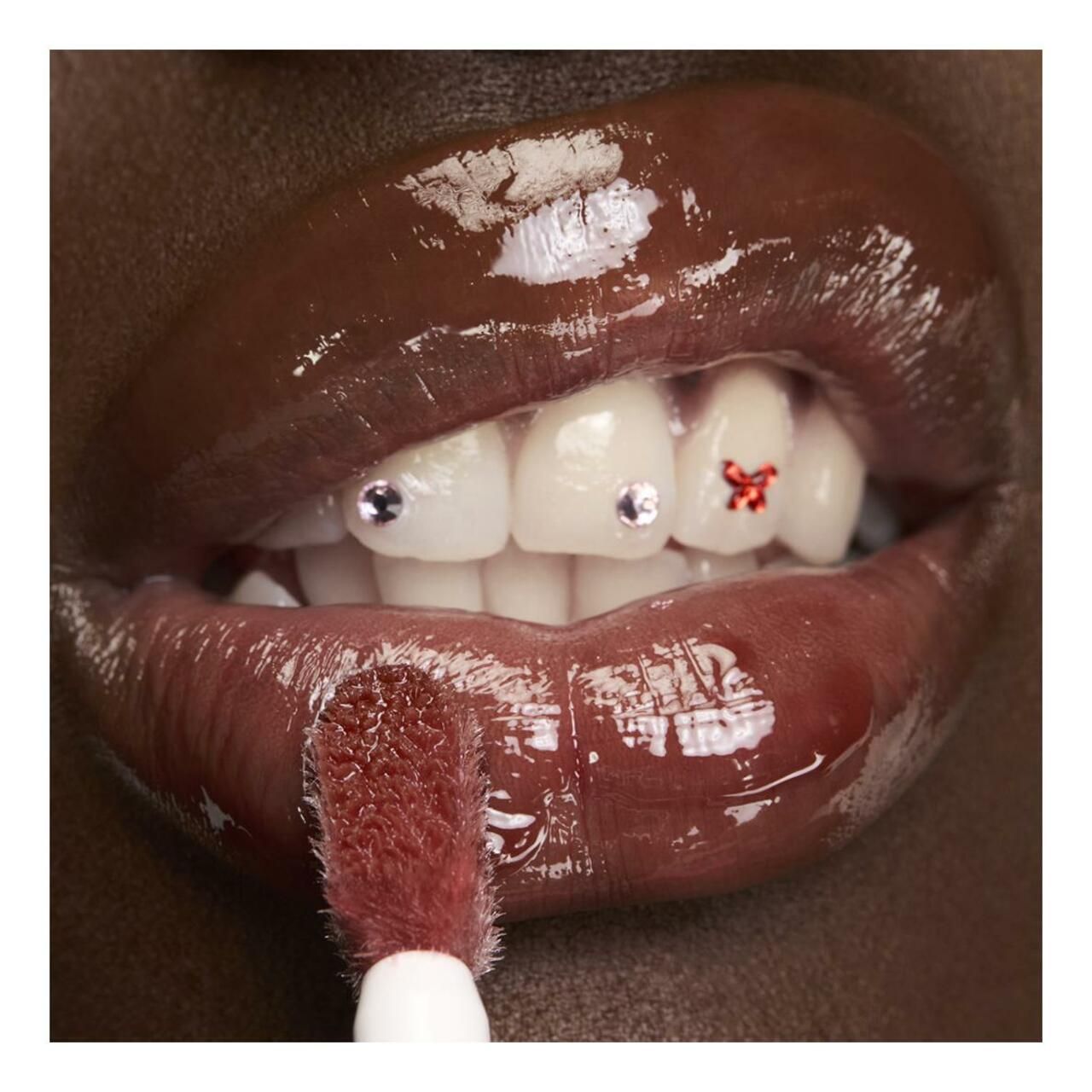 Lippen mit Lippenpflege. Applikator sichtbar. Zähne mit Schmuck.