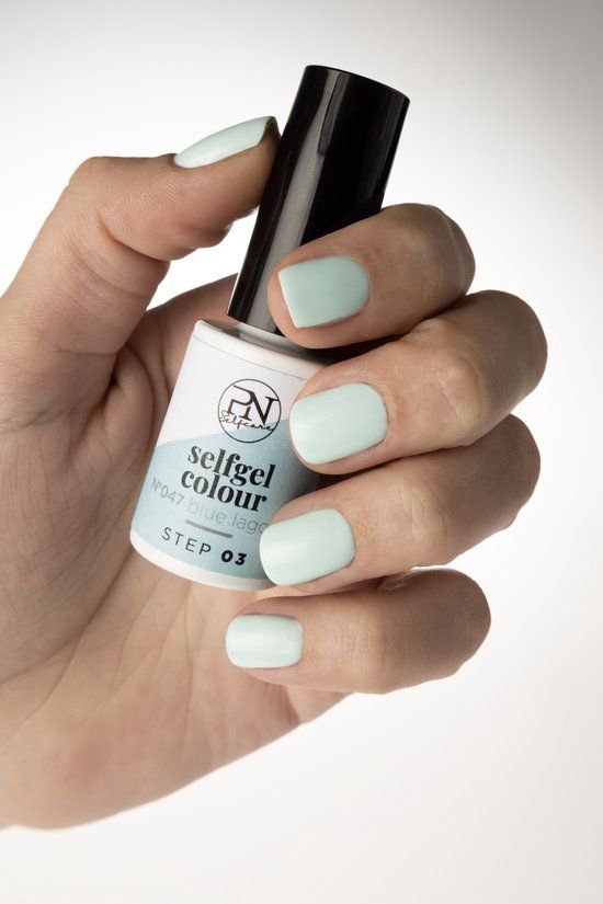 Hand hält eine Flasche PN Selfcare Set Vernis Semi-Permanent in Hellblau. Die Nägel sind passend lackiert.