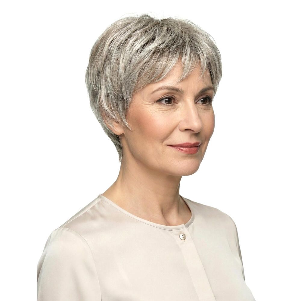 Frau mit Kurzhaarperücke, graue Strähnen. Blick nach vorn, helles Oberteil. Haarschnitt kurz und gestuft.