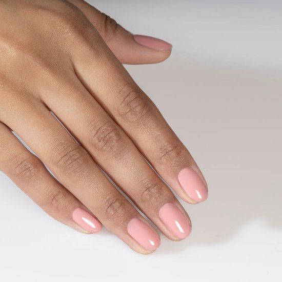 Hand mit lackierten Nägeln in Rosa. Nägel glänzend, oval geformt.