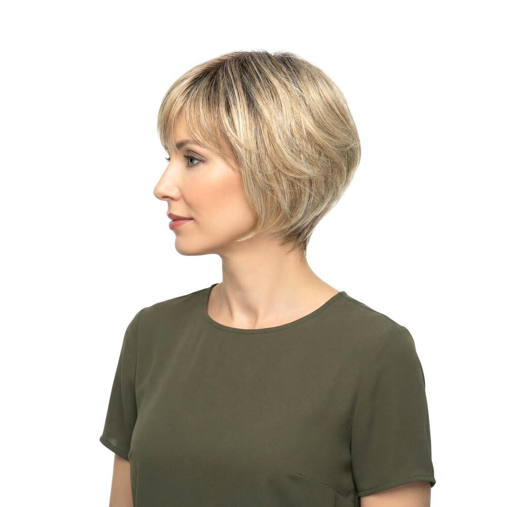 Blonde Perücke mit kurzem, gestuftem Schnitt. Die Frau trägt ein grünes Oberteil. Seitenansicht.