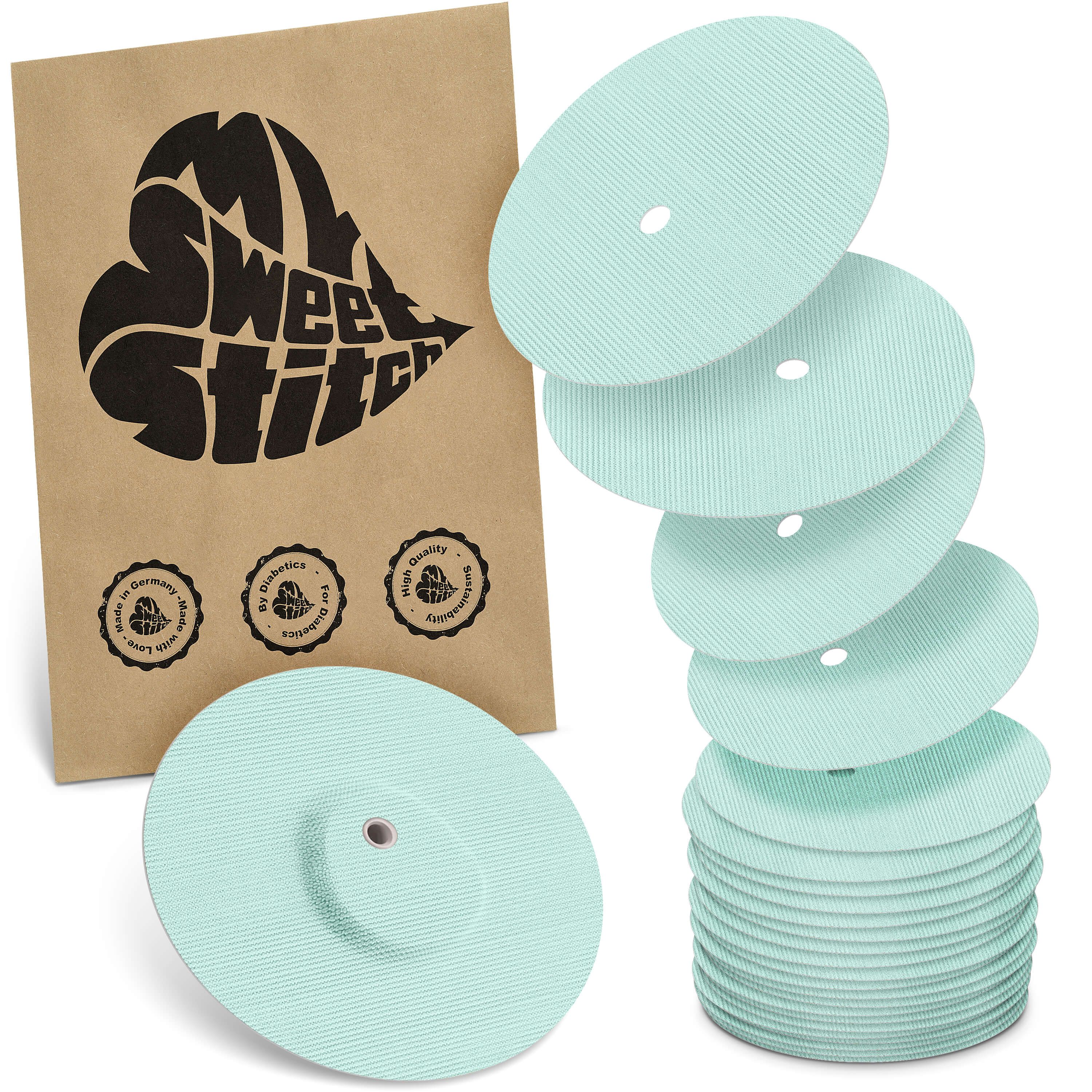 Hellgrüne, runde Pflaster mit zentralem Loch. Einige sind gestapelt, andere liegen daneben. Braune Verpackung mit Logo und Qualitätssiegeln.