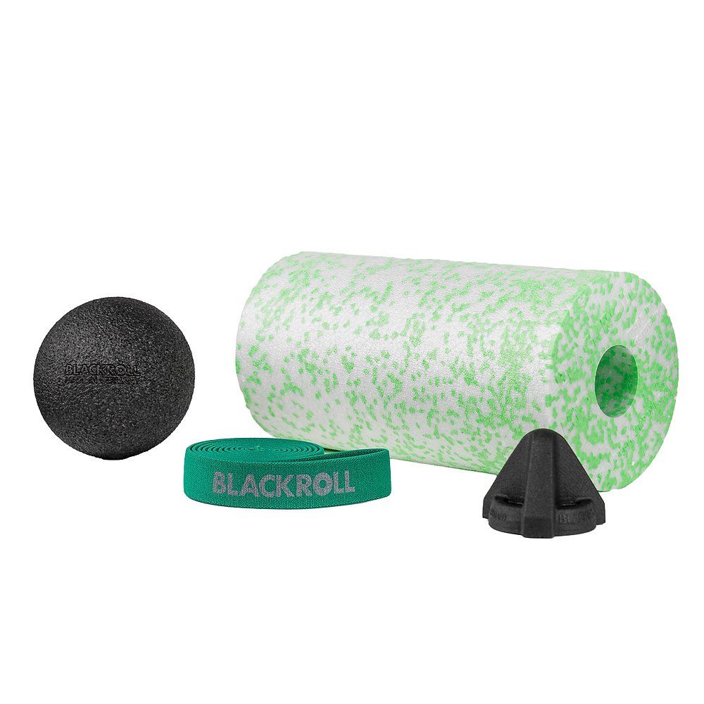 Set mit schwarzem Ball, grünem Band, grünem Roll und schwarzem Dreieck. Auf weißem Hintergrund.