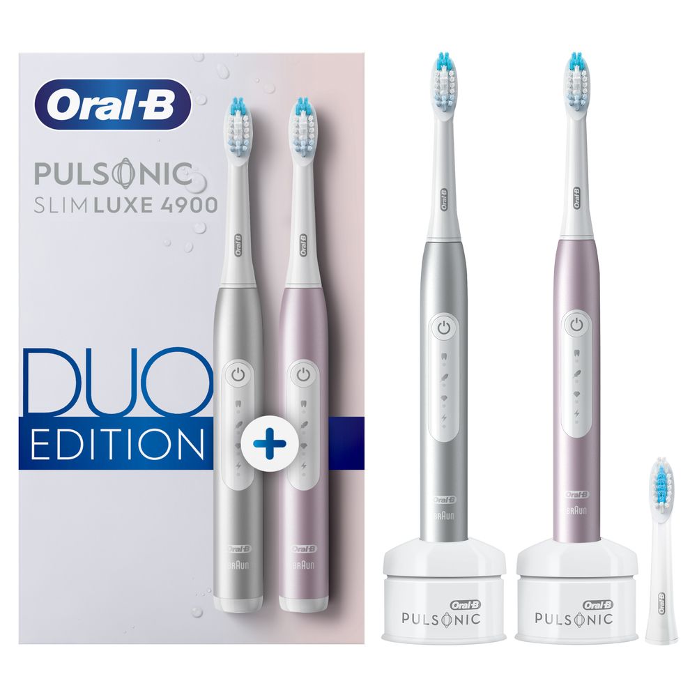 Zwei elektrische Zahnbürsten, silber und rosa, mit Ladestationen und Ersatzbürste. Duo Edition.