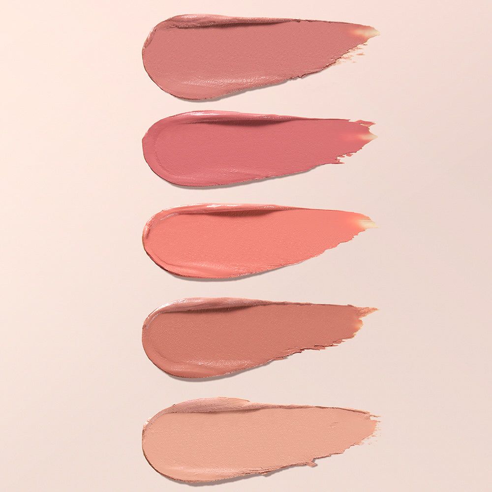 Fünf cremige Lippenstift-Farbproben auf hellem Hintergrund.