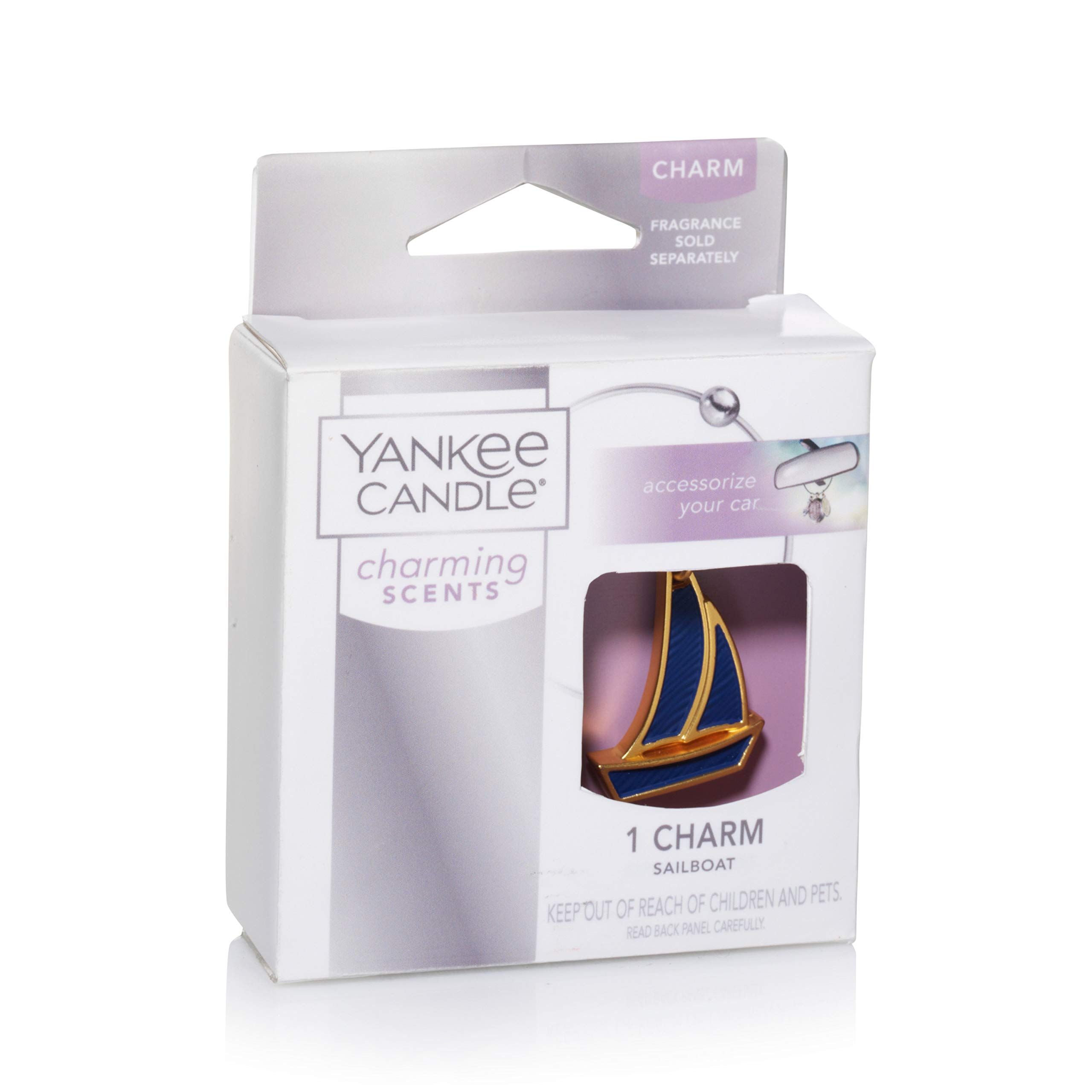 Verpackung mit einem Segelboot-Charm. Charm-Anhänger in Gold und Blau. Marke: Yankee Candle.