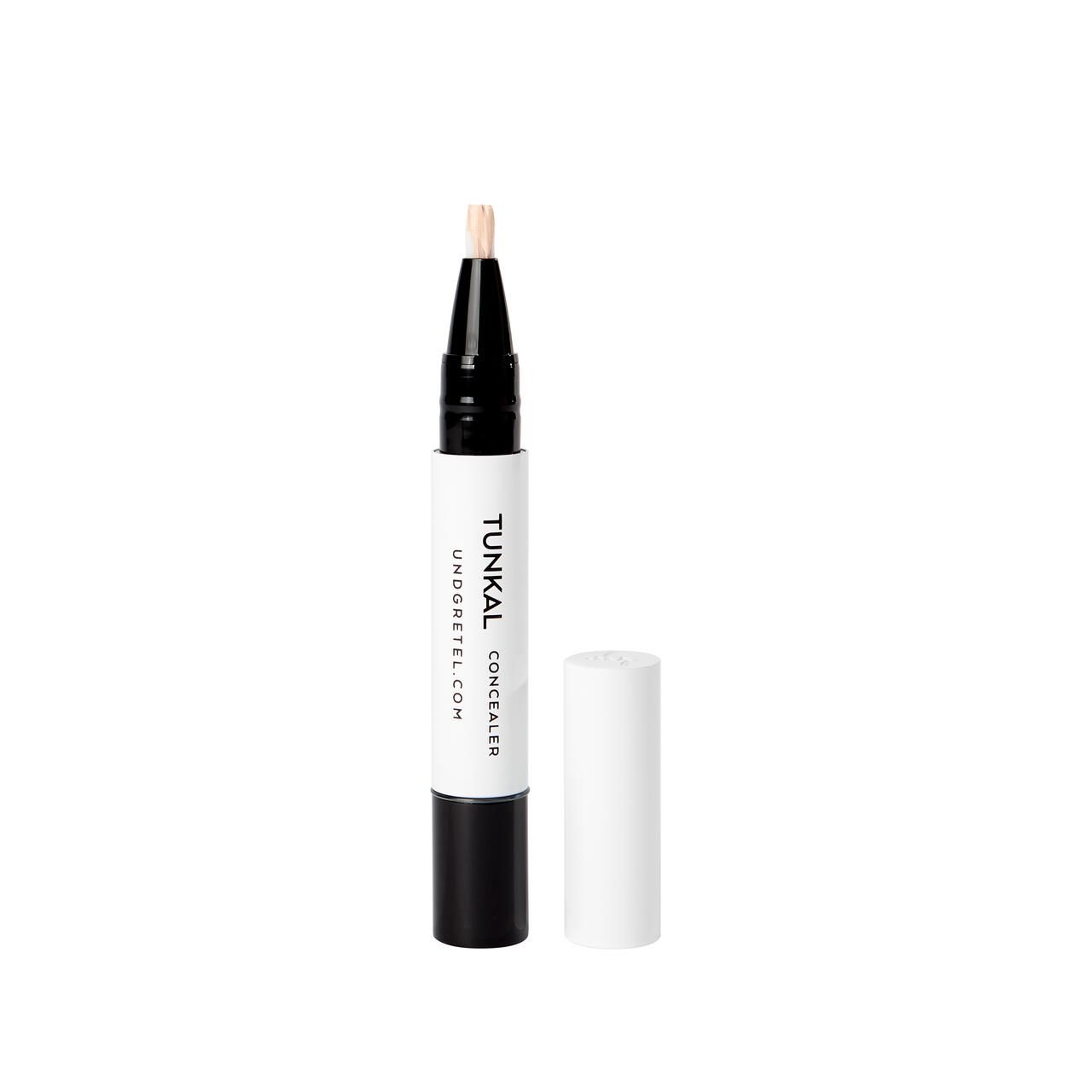 Concealer-Stift mit geöffneter Kappe. Weißer Stift mit schwarzem Ende. Aufschrift: Tunkal Concealer, undgretel.com. Beige Spitze.