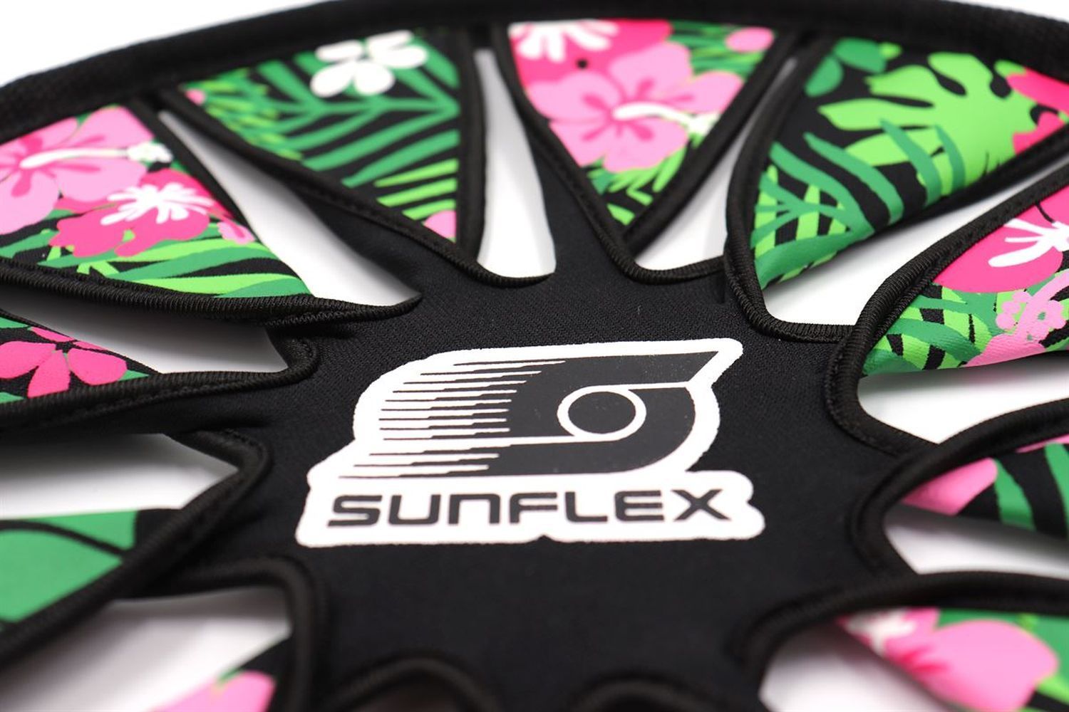 Nahaufnahme des Sunflex Flying Disk. Schwarzer Mittelteil mit Logo. Tropisches Blumenmuster.