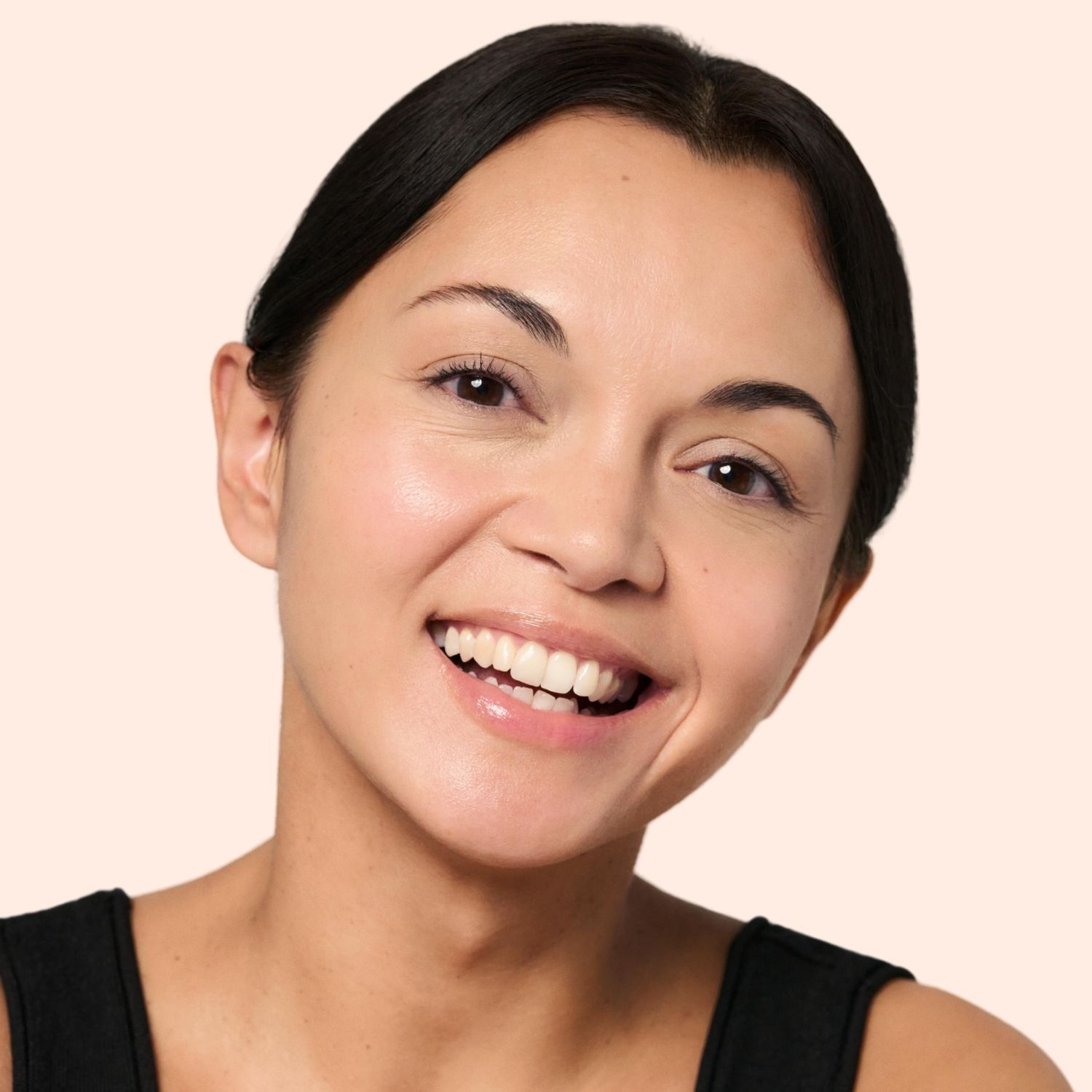 Porträt einer lächelnden Frau. Sie trägt Make-up. Heller Teint, dunkle Haare. Natürliches Licht.