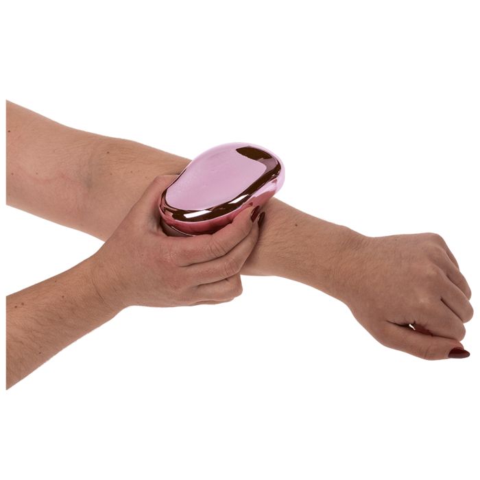 Rosa, ovaler Haarentferner wird auf einem Arm verwendet.