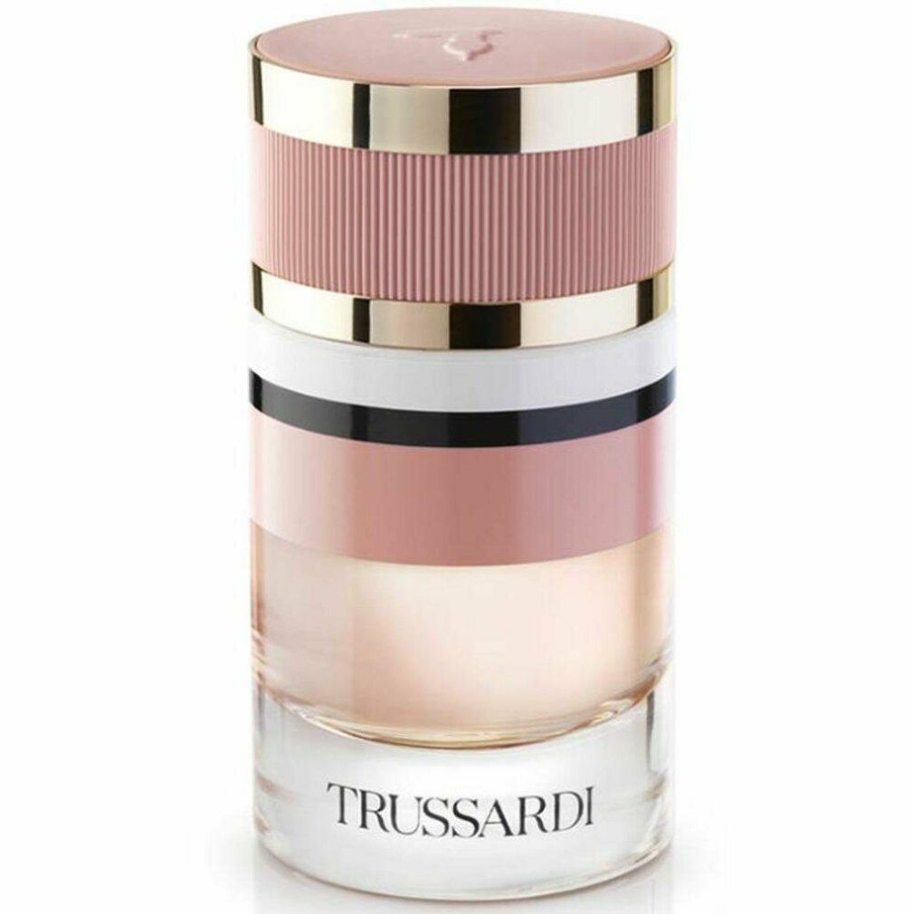 Zylindrischer Parfümflakon. Mehrfarbiges Design mit rosa, weiß, schwarz und goldfarbenen Elementen. Schriftzug Trussardi.