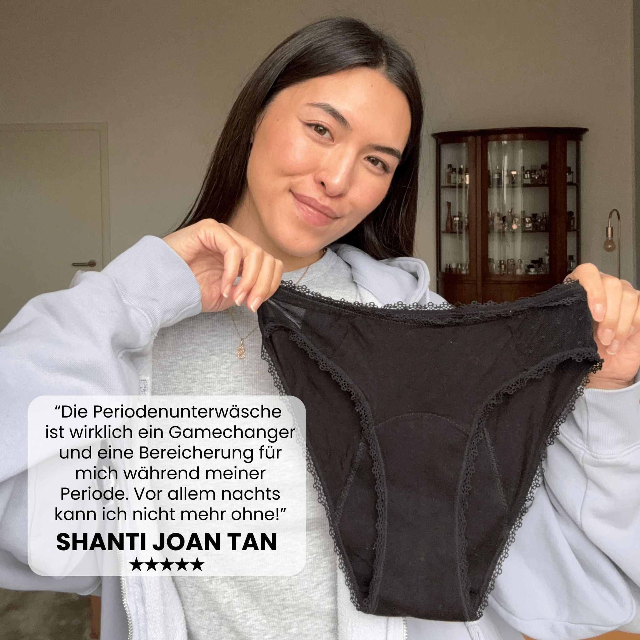 Frau hält schwarzen Slip mit Spitze. Text: Gamechanger für meine Periode. Shanti Joan Tan, 5 Sterne.
