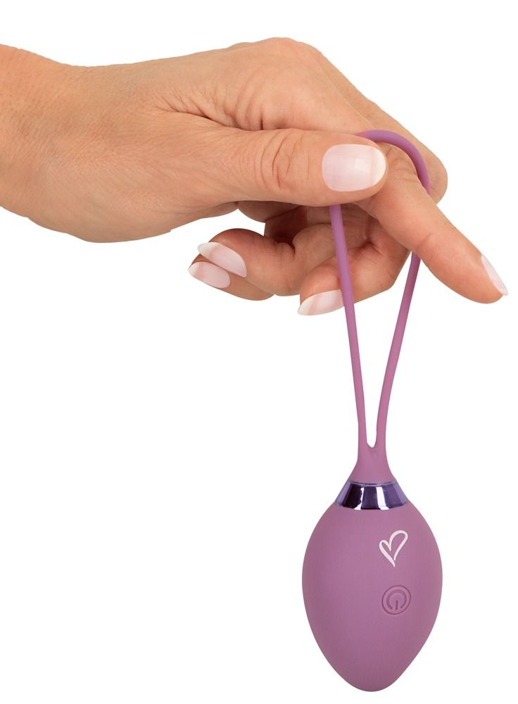 Hand hält eine lila Vibro-Kugel mit Rückholschlaufe.