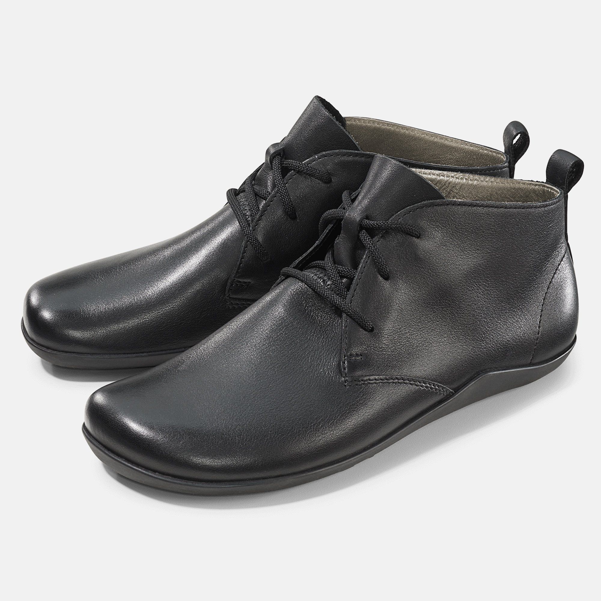 Schwarze Stiefeletten mit Schnürsenkeln. Glattes Leder, flache Sohle. Zwei Schuhe nebeneinander.