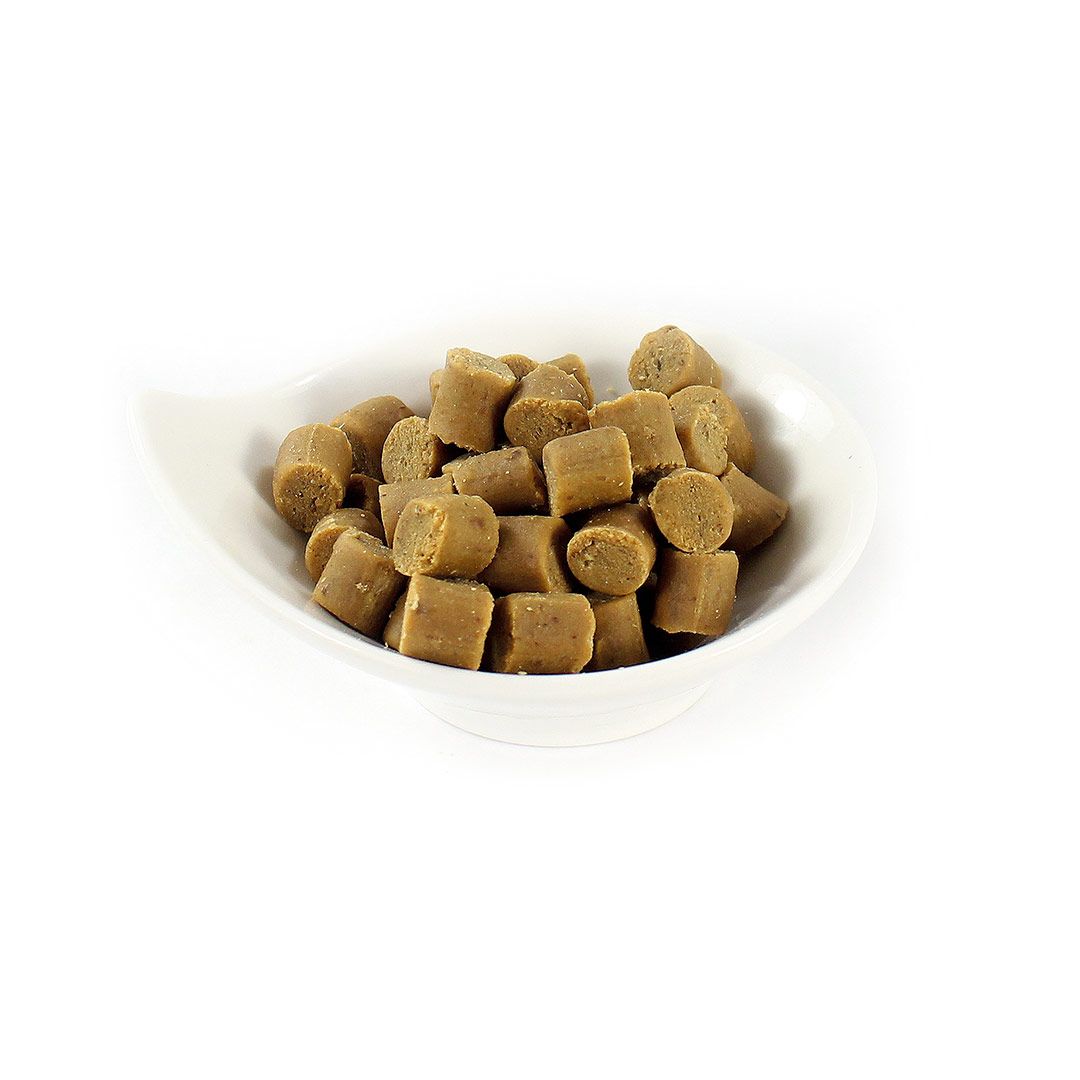 Hundesnacks in einer weißen Schale. Die Snacks sind zylindrisch und hellbraun. Die Schale hat eine unregelmäßige Form.