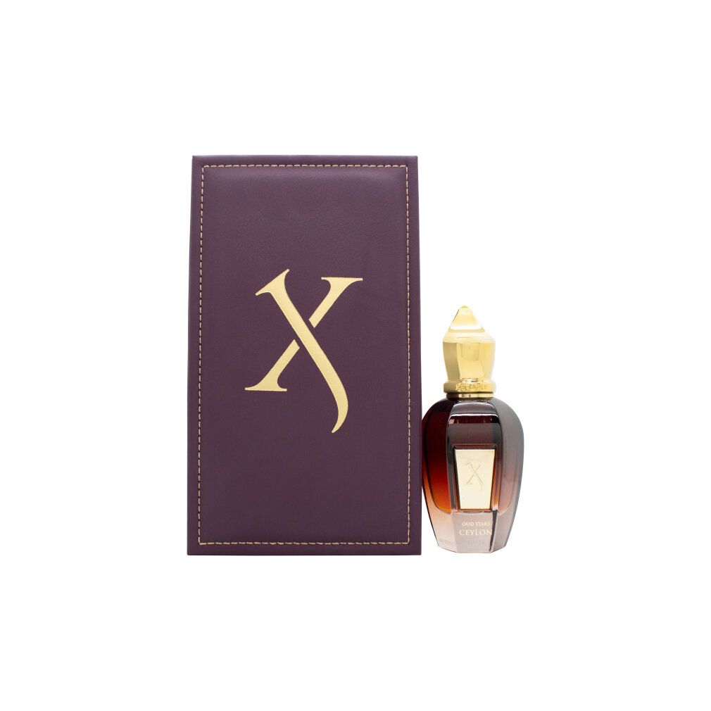 Parfümflakon und Verpackung. Flakon braun, goldener Verschluss. Verpackung lila mit goldenem Logo.