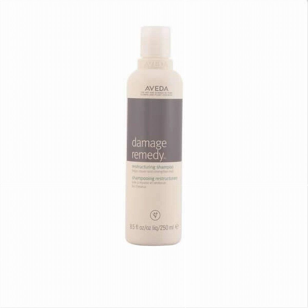 Beige Shampoo-Flasche mit grauem Etikett. Aufschrift: Aveda, Damage Remedy, Restructuring Shampoo. 250 ml.
