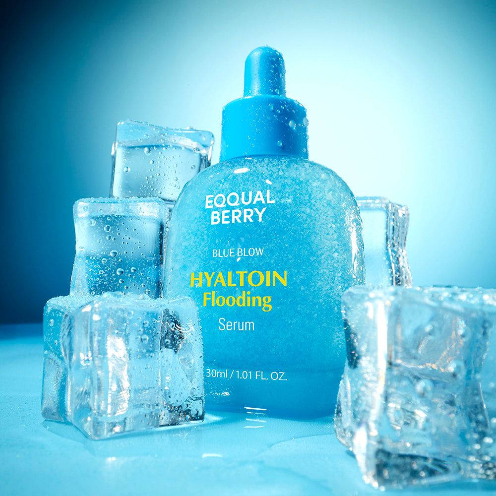 Blaue Glasflasche mit Pipette, beschriftet mit 'EQQUAL BERRY HYALTOIN Flooding Serum', umgeben von Eiswürfeln.