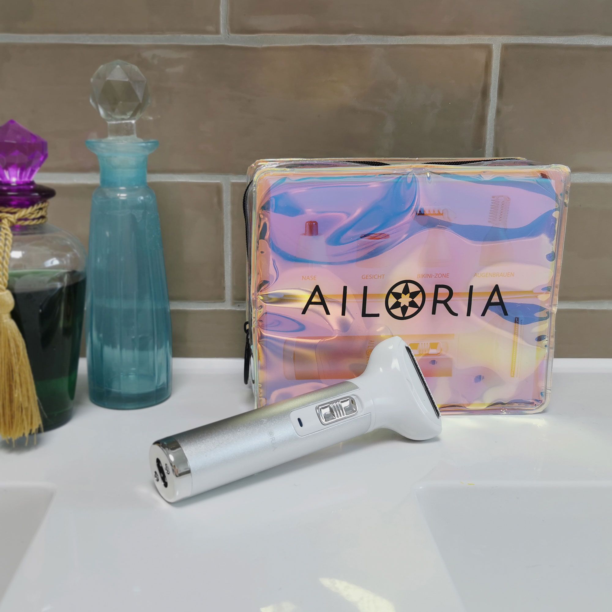 Rasierer und Tasche auf Waschbecken. AILORIA-Logo auf Tasche. Rasierer silberfarben.