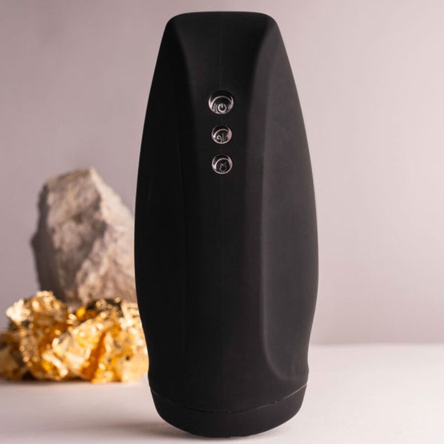 Schwarzes, längliches Gerät mit drei Knöpfen. Im Hintergrund ein Stein und Gold. 