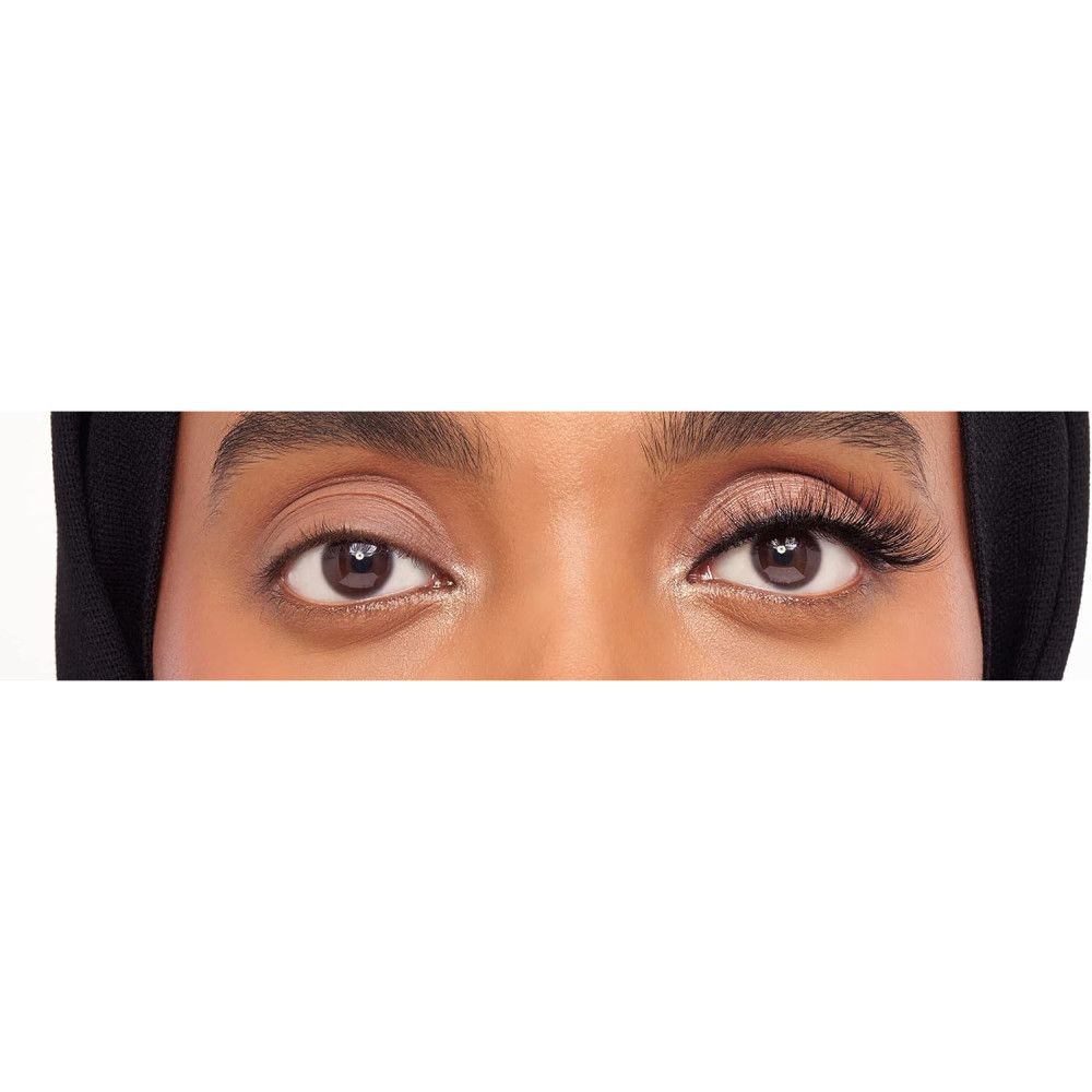 Nahaufnahme von Augen. Ein Auge ohne Wimpern, das andere mit Wimpern. Schwarzer Hintergrund.