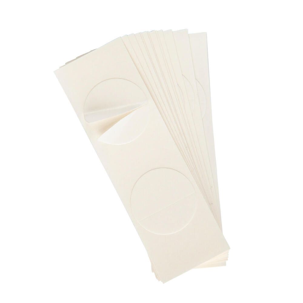 Stapel rechteckiger, cremefarbener Haftpunkte mit kreisförmigen Aussparungen. Ein Punkt ist teilweise abgezogen.