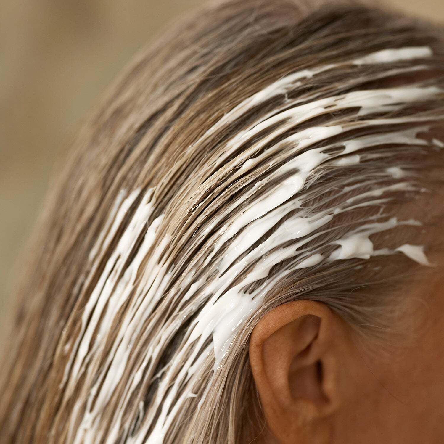 Haar mit Haarmaske bedeckt. Maske: weiß. Haare: blond. Anwendung.